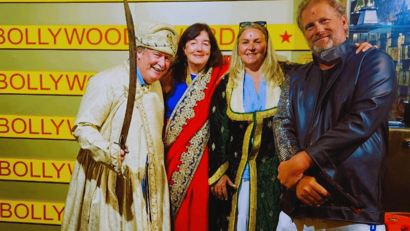 Tourists posing in traditional Bollywood costumes during a Mumbai film studio tour experience