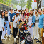 Travelers interacting with local Mumbai workers during a cultural Highlights of Mumbai guided city tour