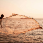 Local fisherman casting a net at sunset on the Goan coast