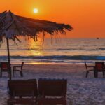 Sunset at Candolim Beach Goa with beach chairs, umbrellas and calm sea