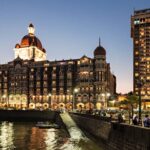 Taj Mahal Palace Hotel Mumbai illuminated at dusk near Gateway of India